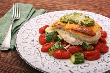 Tasty baked chicken breasts which basil pesto sauce, tomatoes, and cheese. Healthy eating concept.