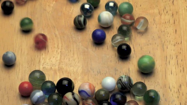 Rolling marbles on wooden board