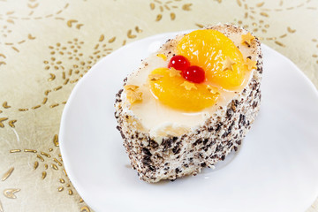 mini cake with cream, berries and slices of mandarin