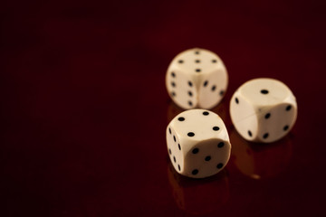 three dice cubes on dark reflecting wooden background games fortune