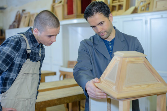 cabinetmaker teaching a young man his job