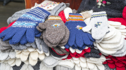 Obraz na płótnie Canvas Group of handmade colorful knitted socks, mittens, gloves and hats in the market.