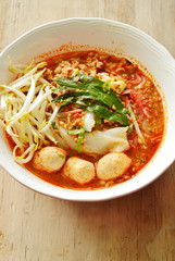 rice noodle with pork ball in tom yum spicy soup topping fresh bean sprout on bowl
