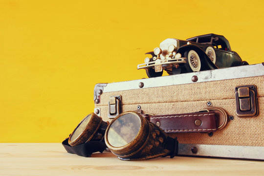 vintage toy car and old suitcase next to pilot glasses