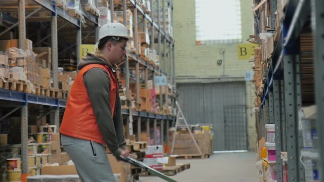 Warehouse Worker Raises Goods