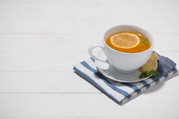 Cup of Ginger Tea with Lemon and Honey on a White Wooden Backgro