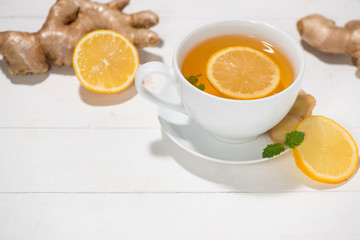 Cup of Ginger Tea with Lemon and Honey on a White Wooden Backgro
