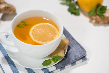 Cup of Ginger Tea with Lemon and Honey on a White Wooden Backgro