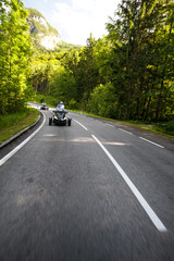 Obraz premium Two of the crew on the three-wheeled motorcycle ride on a forest road in the Salzkammergut region in Austria 