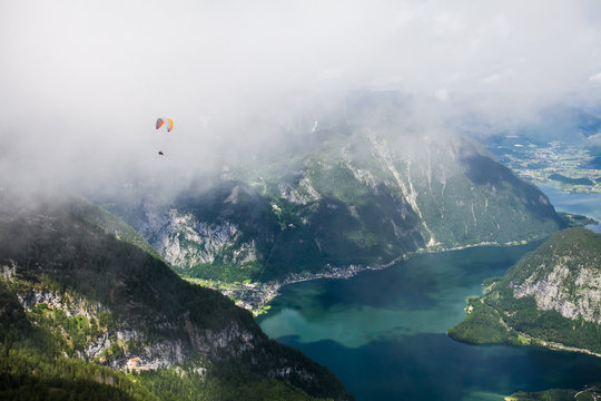 Racing with the cloud. Flying with parachute over mountains and lakes.