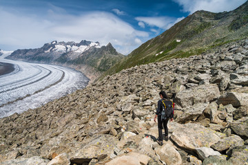 Naklejka premium Girl walking on spectacular mountain scenery, Aletsch glacier in background Alps, Switzerland.
