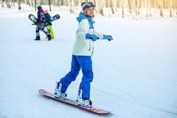 female snowboarder snowboarding down the mountain