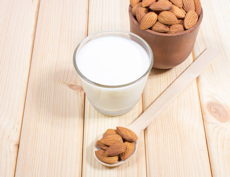 Almond milk with almond on a wooden table.