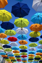 Fototapeta na wymiar Colorful umbrellas background. Colorful umbrellas in the sunny sky. Street decoration.