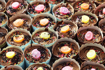 Homemade Chocolate Cupcake with colorful candy topping as backgr