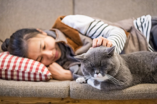 Girl and cat sleeping on the couch
