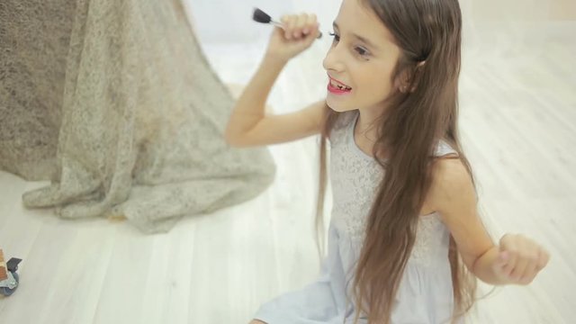 little girl is painted before a mirror her mother's makeup