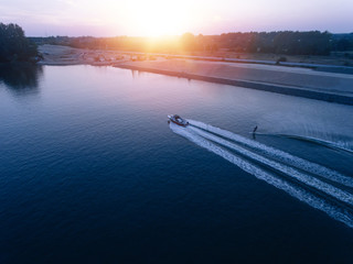 Man water skiing on lake behind boat