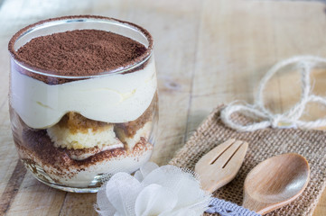tiramisu cake homemade on wooden background. fork and spoon