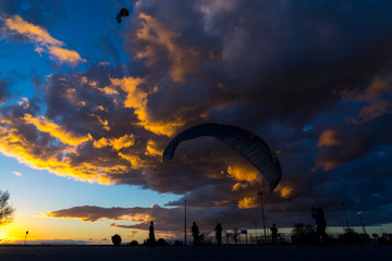 Silhouette skydiver parachutist training at sunset