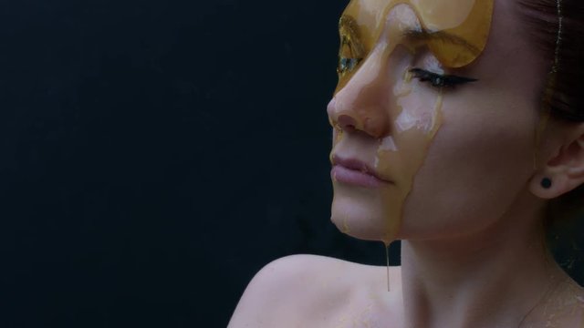 4k shoot of a model in studio with honey pouring on her face