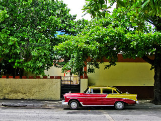 Vintage car parked at an apartment building in Havana, Cuba