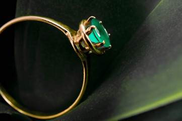 gold ring with an emerald on leaf