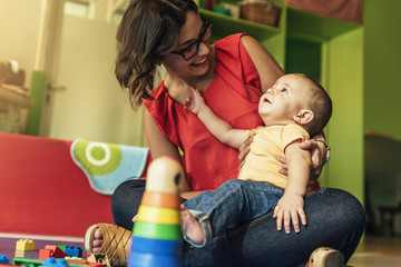 Child boy and mother playing.