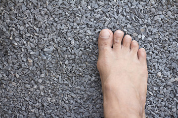 man bare feet in rocks