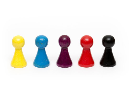 bunte Spielsteine aus Holz stehen in einer Reihe