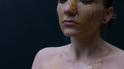 4k shoot of a model in studio with honey pouring on her face