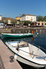 Fototapeta na wymiar Sailboats and fishing boats at Porto di Bardolino harbor on The Garda Lake . Italy