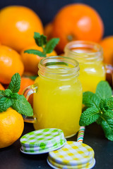 orange juice in a jar with citrus on a dark background