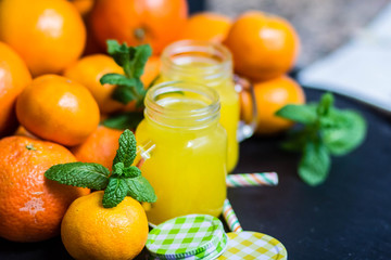 orange juice in a jar with citrus on a dark background