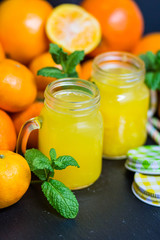 orange juice in a jar with citrus on a dark background