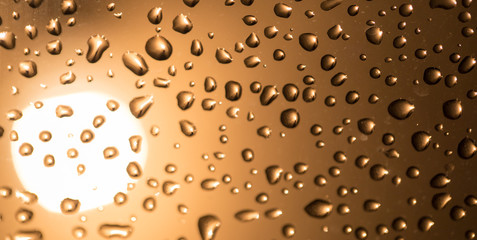 Water drops on the glass at sunset