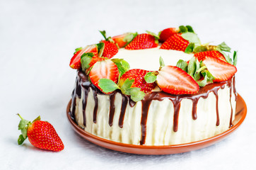 Sponge cake with cream, chocolate and strawberry