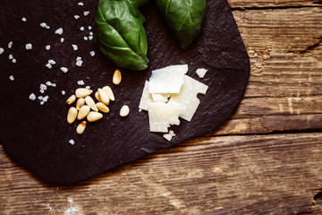 Käse, Nüsse und Basilikum für Pesto auf einer Schieferplatte