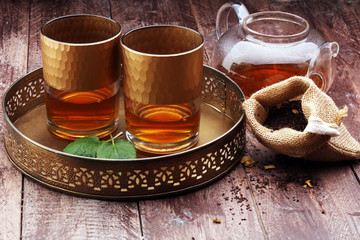 Tea. Herbal tea. Mint leaf. Tea in a glass cup, mint leaves, dried tea, sliced lime. herbs on a slate plate in a restaurant or teahouse 