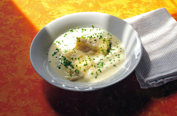 Cottage cheese dumplings in whey soup with chives on top