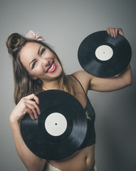 Laughing retro pin up girl holding vinyl records