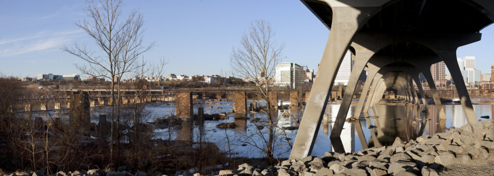 Late winter afternoon panorama in Richmond, Virginia looking north from under the Manchester Floodwall Walk with the T. Tyler Potterfield pedestrian bridge spanning the James River to the left. 