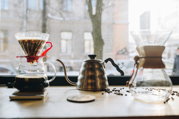 Glass picthers and coffee beans on the desk near window
