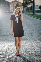 Fototapeta premium Blonde woman with high heel shoes posing outdoor in city