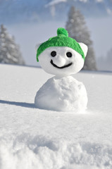 Funny snowman against Swiss Alps