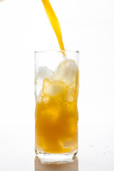 Pouring Orange Juice to the ice glass 