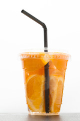 Orange juice with black straw on a white.
