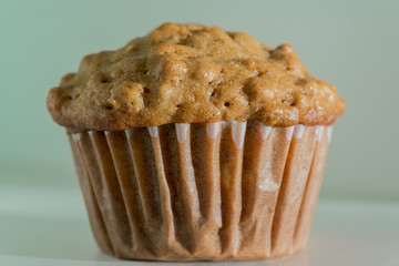 Closeup of delicious homemade baked bran muffin on light blue aq