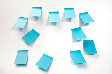 Blue sticky papers on a wall.