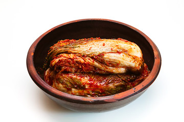 Kimchi on a crock head on white background